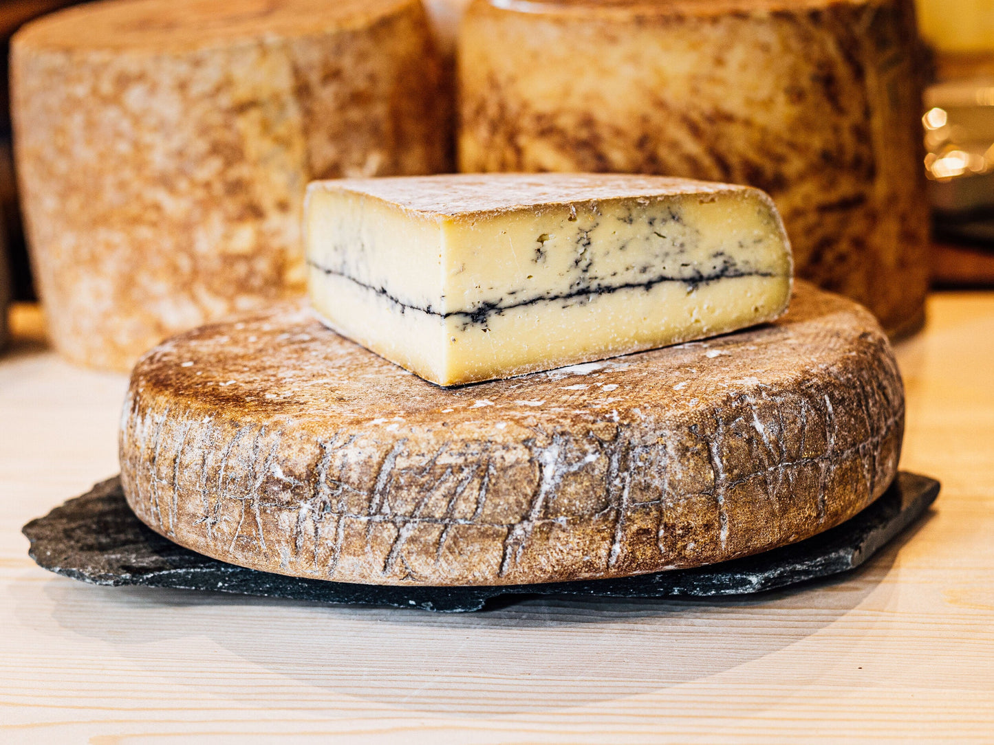 A rustic looking large, rinded cheese. Pale in colour, with a distinctive line of ash running through its centre