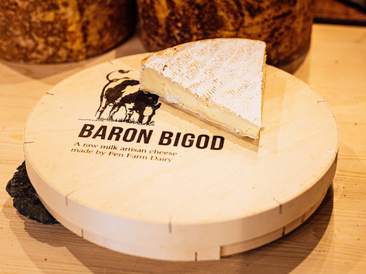 A large wedge of rich, creamy Baron Bigod Brie, sitting on top of it's spruce wood box
